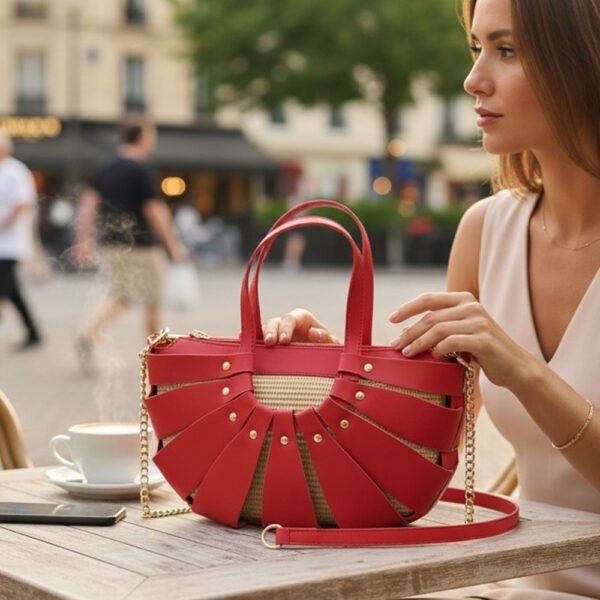 Ženska elegantna torbica s lancem u crvenoj boji na stolu u gradu