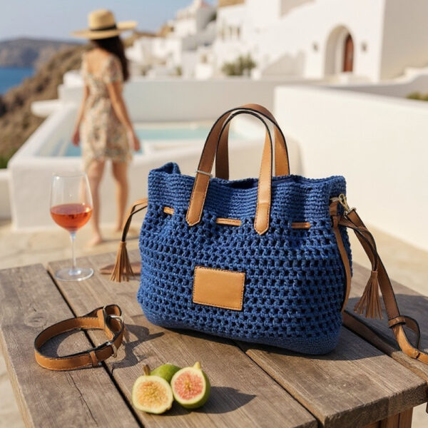 Ženska pletena torbica s remenom na stolu u ljetnom turističkom okruženju
