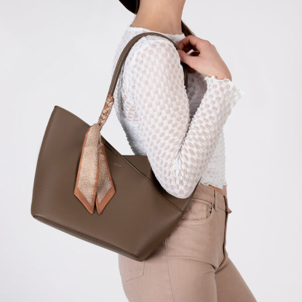 Ženska Rieker shopper torba u bež boji s minimalističkim dizajnom, dekorativnom maramom na ručki i prostranom unutrašnjošću.