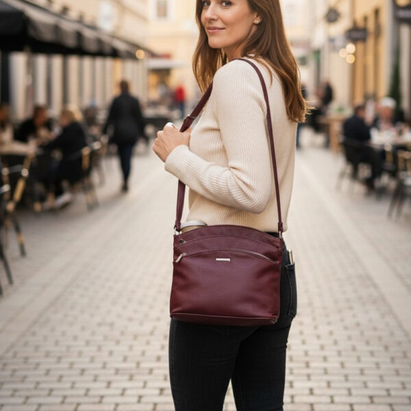 Ženska city crossbody torba bordo boje s podesivim remenom, patentnim zatvaračem i praktičnim vanjskim džepovima za svakodnevno nošenje.