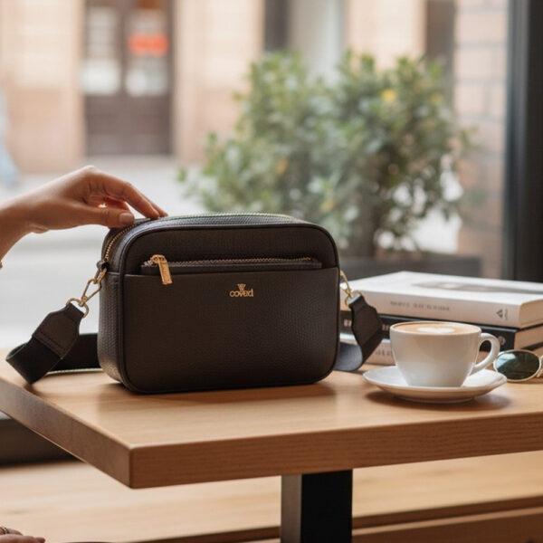 Crna Coveri ženska crossbody torba s podesivim širokim remenom, prednjim džepom na patent i elegantnim minimalističkim dizajnom.